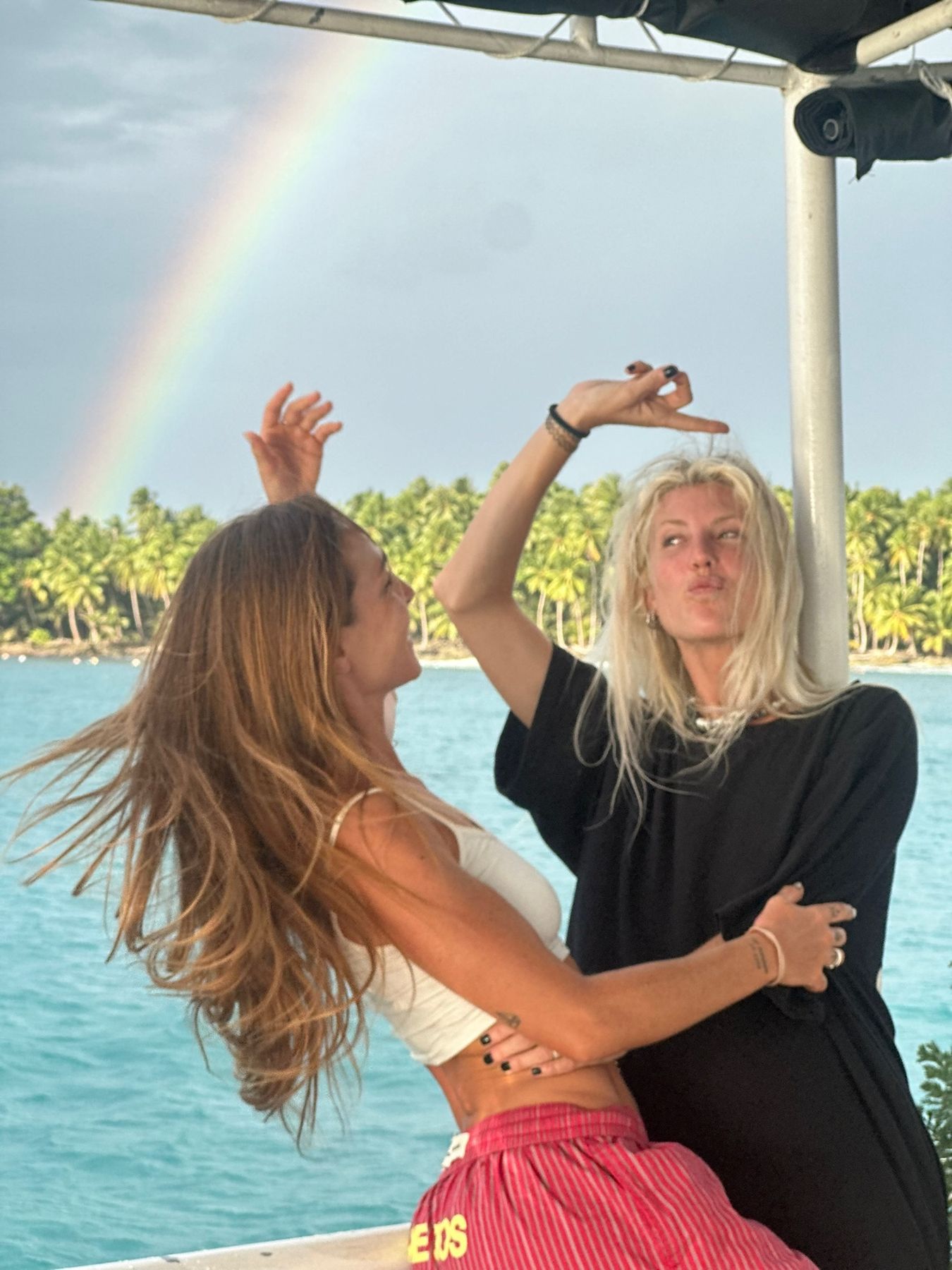 Guests dancing on deck under a rainbow